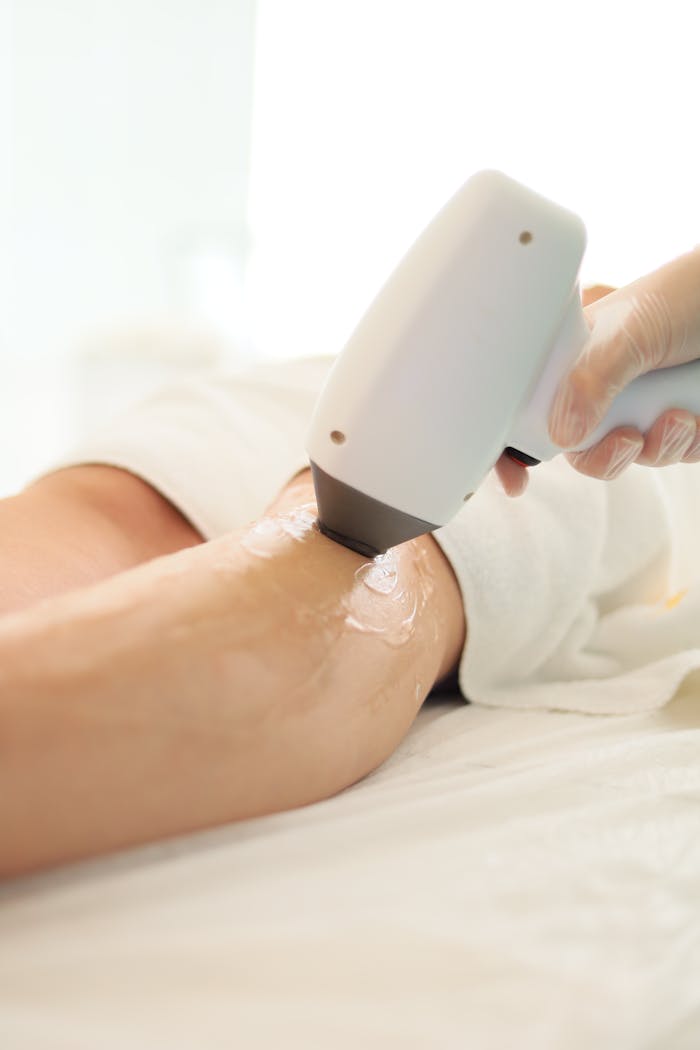 why-choose-us Close-up of laser hair removal being performed on an arm in a spa setting.