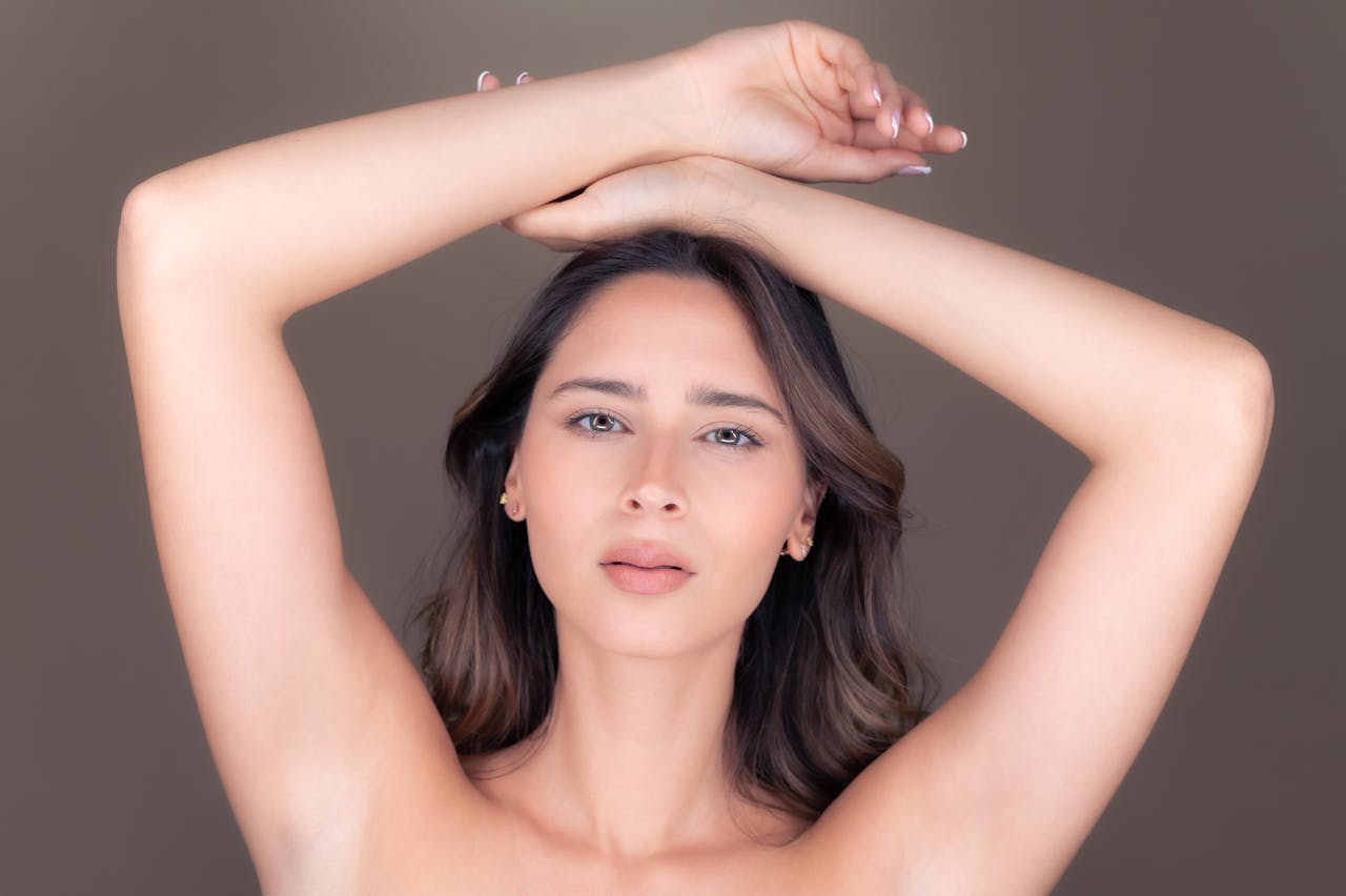 gallery-4 A graceful portrait of a beautiful brunette woman posing with arms raised in a studio setting.